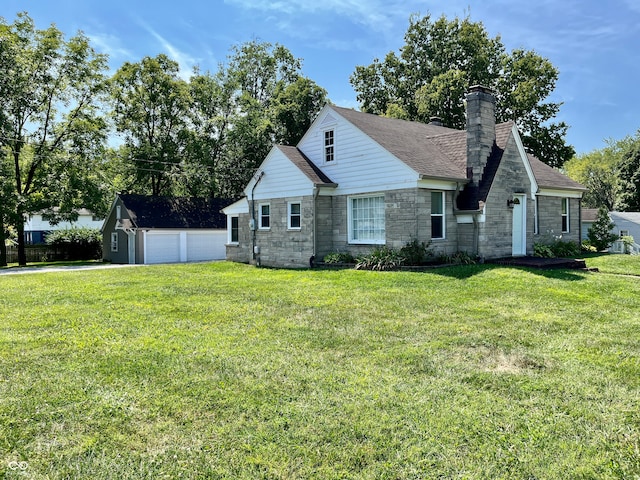 view of front of home with a garage, a front yard, and an outdoor structure