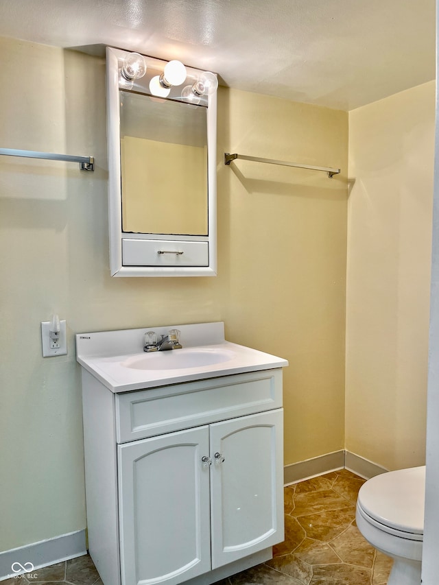 bathroom featuring toilet, vanity, and tile patterned flooring