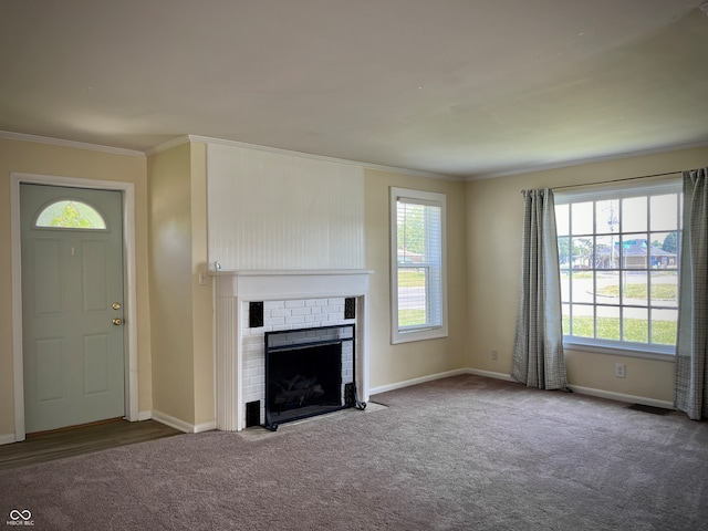 unfurnished living room with carpet, crown molding, and a brick fireplace