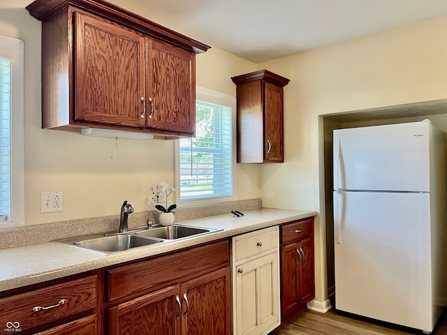 kitchen featuring hardwood / wood-style floors, sink, and white fridge