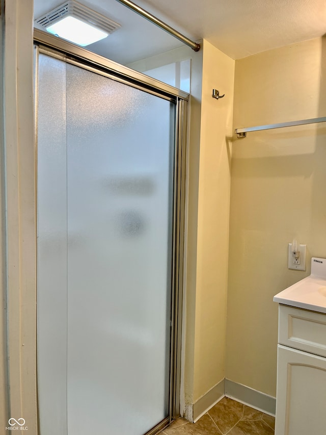 bathroom featuring walk in shower, vanity, and tile patterned floors