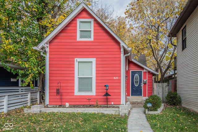 bungalow-style home with a front yard