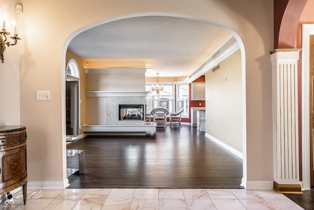 hall with a wealth of natural light, crown molding, a textured ceiling, and light hardwood / wood-style flooring