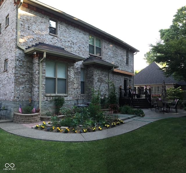 rear view of property with a yard, a patio area, and a wooden deck