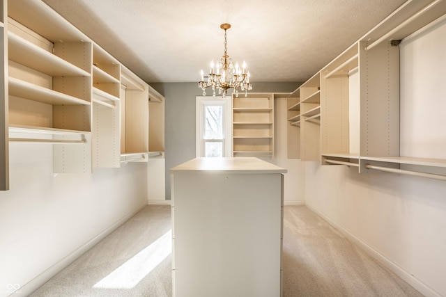 walk in closet featuring light carpet and a chandelier