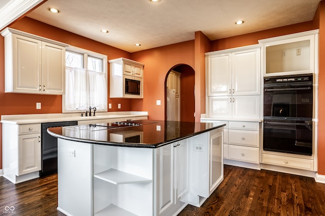 kitchen with white cabinetry, a kitchen island, double oven, and built in microwave