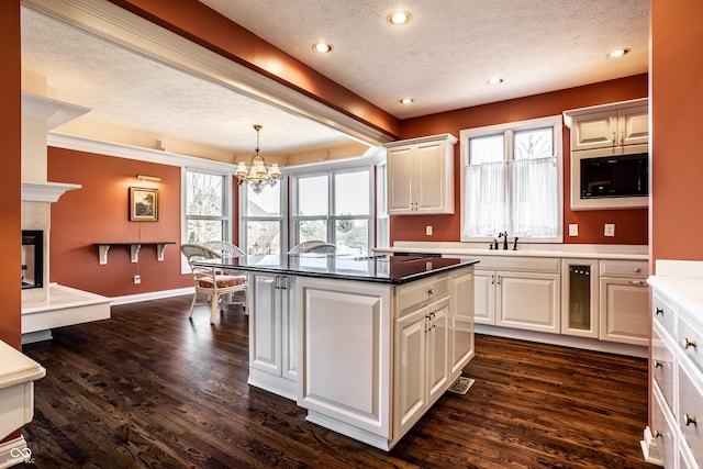 kitchen featuring dark hardwood / wood-style flooring, stainless steel microwave, and a textured ceiling