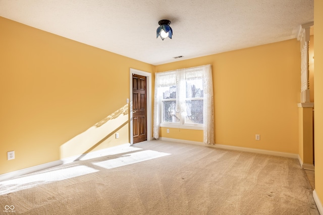 unfurnished room with a textured ceiling and light colored carpet