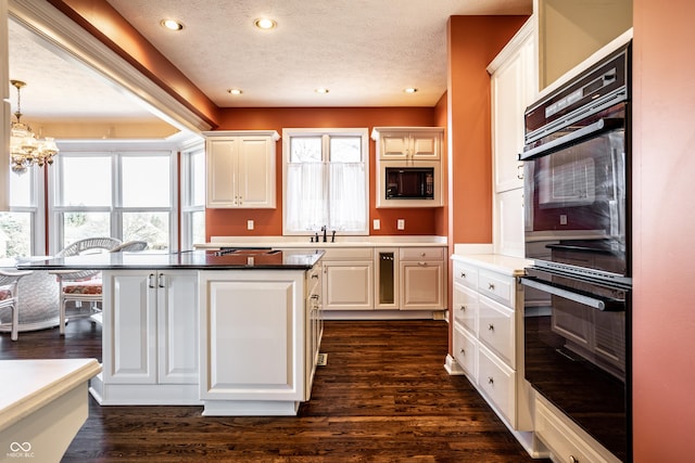 kitchen featuring white cabinets, black appliances, hanging light fixtures, dark hardwood / wood-style floors, and a textured ceiling