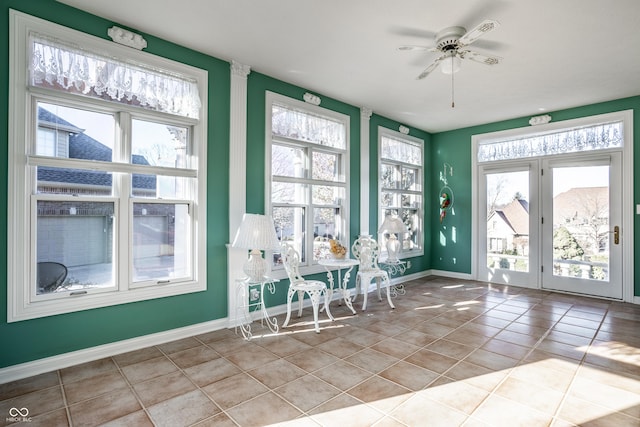 unfurnished sunroom with ceiling fan and a healthy amount of sunlight