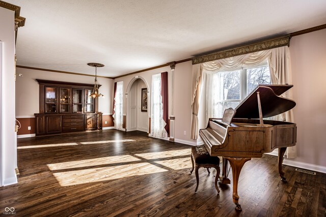 interior space with dark hardwood / wood-style flooring, ornamental molding, and a chandelier