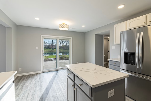 kitchen featuring gray cabinetry, white cabinets, stainless steel fridge with ice dispenser, a kitchen island, and light wood-type flooring