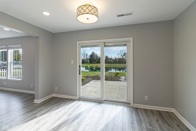 empty room with wood-type flooring and a water view