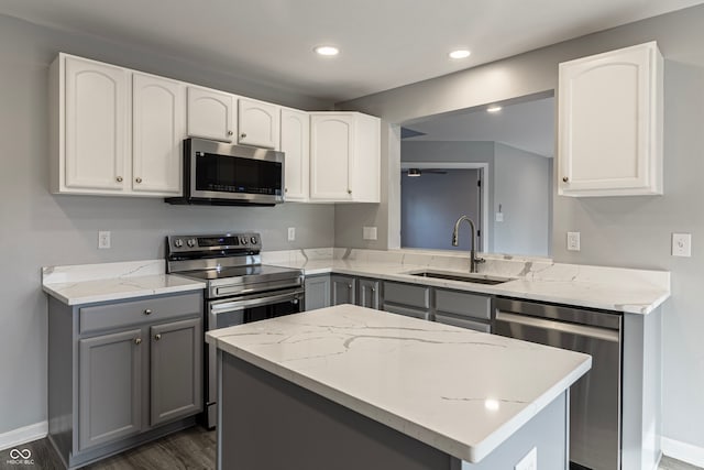 kitchen with gray cabinetry, stainless steel appliances, dark wood-type flooring, sink, and white cabinetry