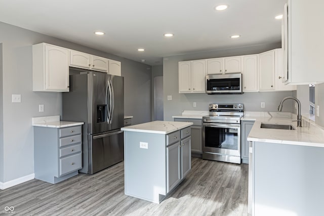 kitchen featuring a center island, white cabinets, sink, gray cabinets, and stainless steel appliances