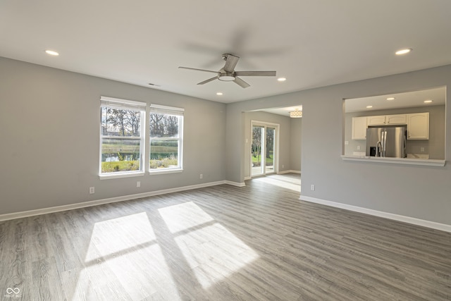 unfurnished living room with ceiling fan and light hardwood / wood-style flooring