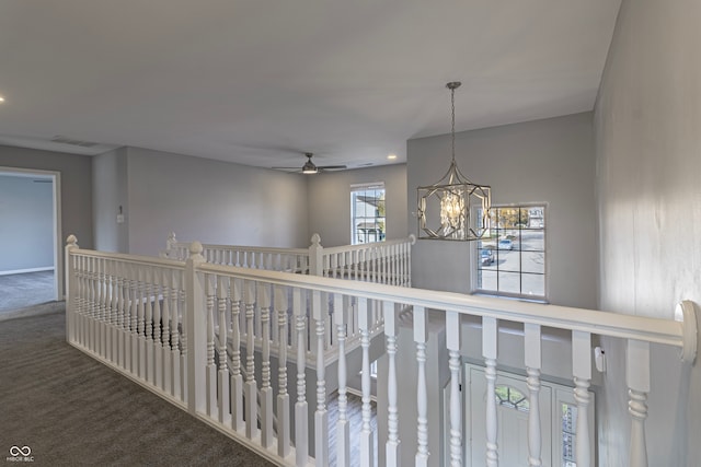 hallway with carpet floors and a notable chandelier