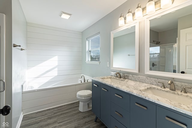 full bathroom featuring separate shower and tub, hardwood / wood-style floors, vanity, and toilet