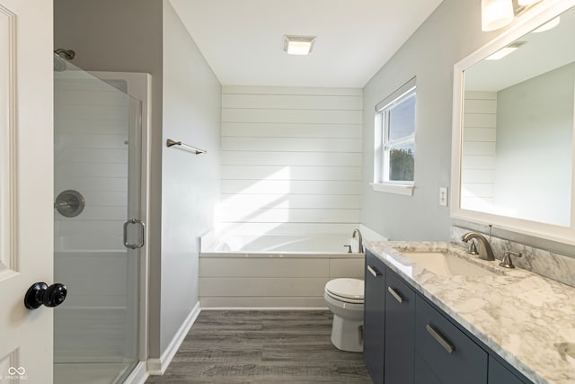 full bathroom with hardwood / wood-style floors, vanity, toilet, and plus walk in shower