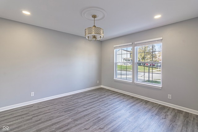 unfurnished room with dark hardwood / wood-style floors and a notable chandelier