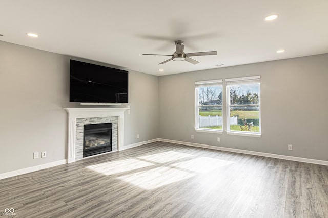 unfurnished living room with a fireplace, hardwood / wood-style floors, and ceiling fan