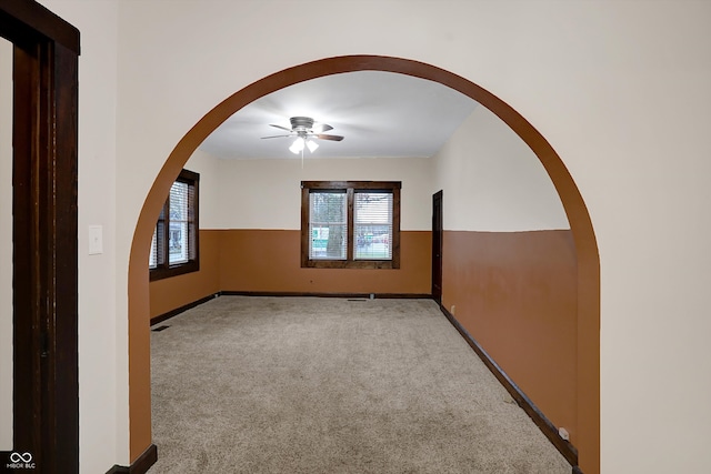 unfurnished room with light colored carpet and ceiling fan