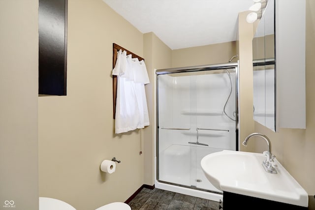 bathroom with toilet, sink, and a shower with shower door