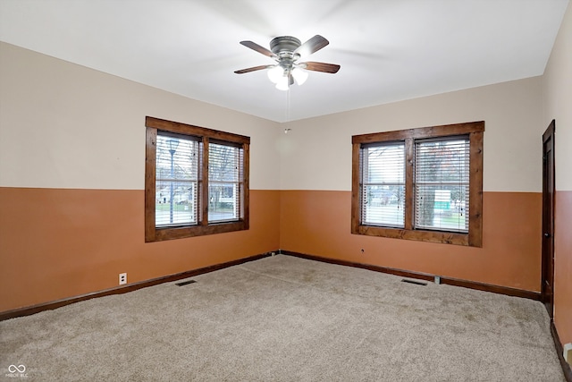 carpeted spare room with ceiling fan