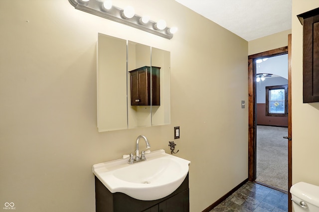 bathroom featuring ceiling fan, vanity, and toilet