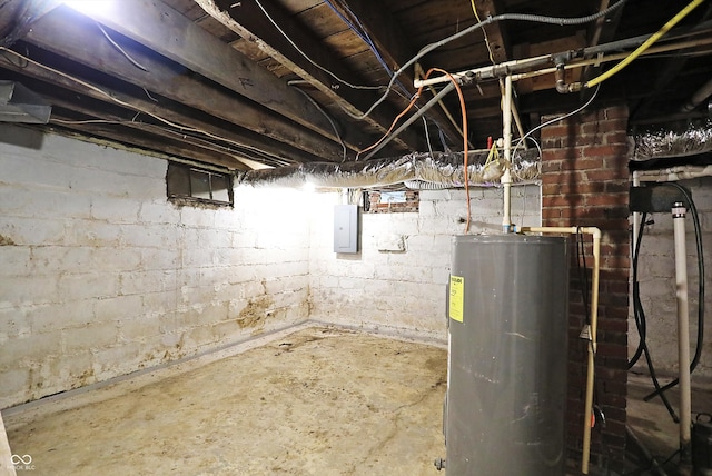 basement featuring electric panel and water heater