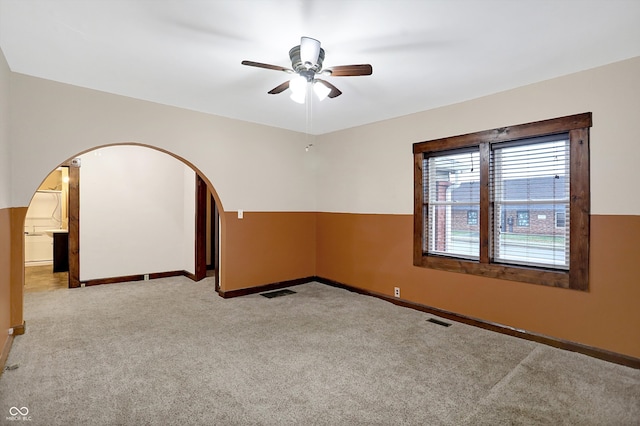 empty room featuring ceiling fan and light carpet