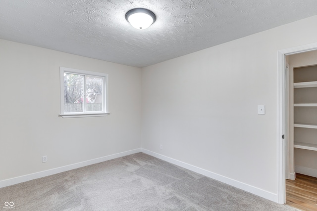 carpeted spare room with a textured ceiling