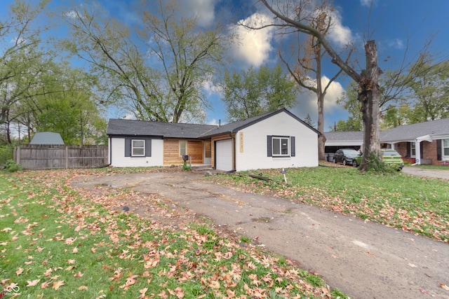 ranch-style home with a garage and a front yard