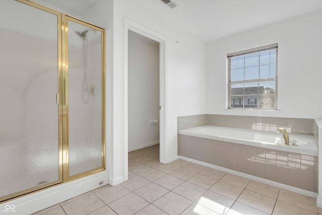 full bathroom featuring tile patterned flooring, a bath, a shower stall, and baseboards