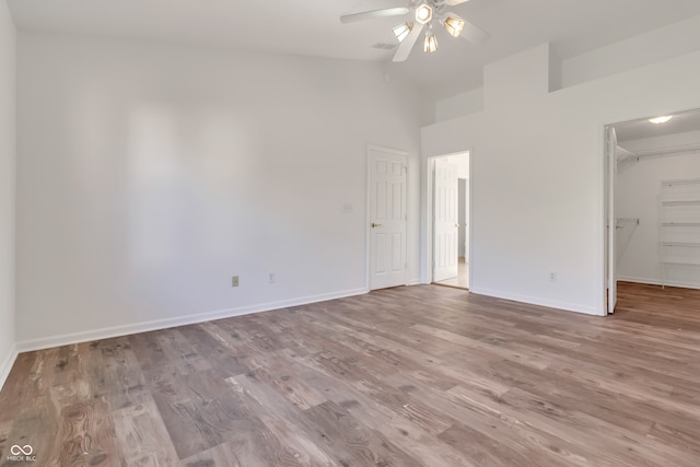 interior space with light hardwood / wood-style floors, high vaulted ceiling, ceiling fan, a closet, and a spacious closet