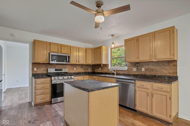 kitchen with appliances with stainless steel finishes, ceiling fan, wood finished floors, and decorative backsplash