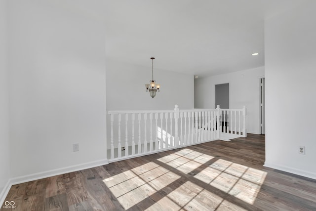 unfurnished room with wood finished floors, a chandelier, baseboards, and recessed lighting