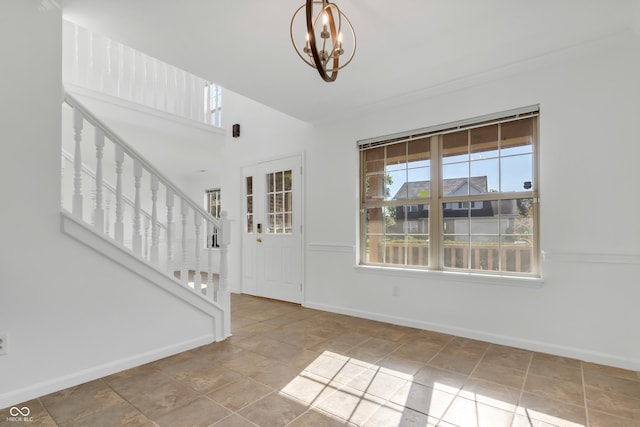 entryway featuring a chandelier, baseboards, stairs, and ornamental molding