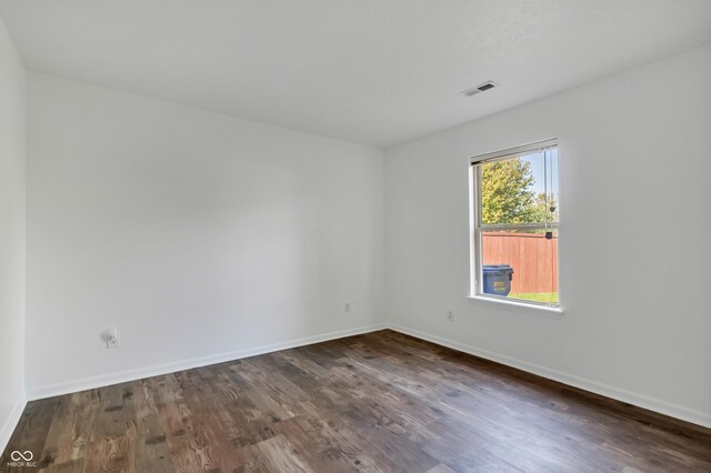 spare room with dark wood-style floors and baseboards