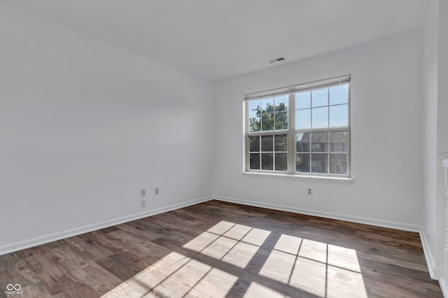 empty room with dark hardwood / wood-style flooring