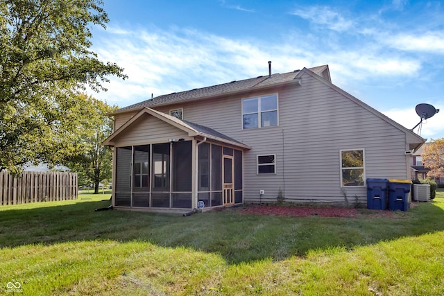 back of property featuring central air condition unit, a sunroom, and a yard