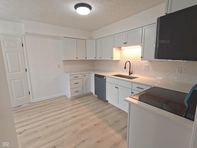 kitchen featuring light hardwood / wood-style floors, white cabinets, sink, tasteful backsplash, and dishwashing machine