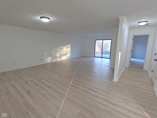 unfurnished room featuring light hardwood / wood-style floors and a textured ceiling