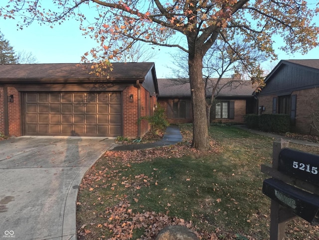 ranch-style home featuring a garage and a front lawn