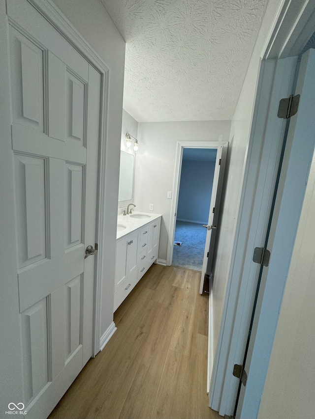 bathroom featuring hardwood / wood-style floors, vanity, and a textured ceiling