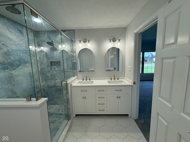 bathroom featuring vanity, a shower with shower door, a textured ceiling, and tile patterned flooring