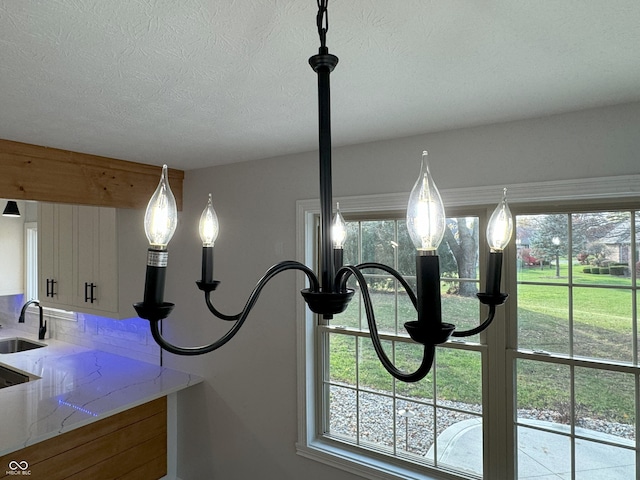 details with a textured ceiling, sink, and decorative backsplash