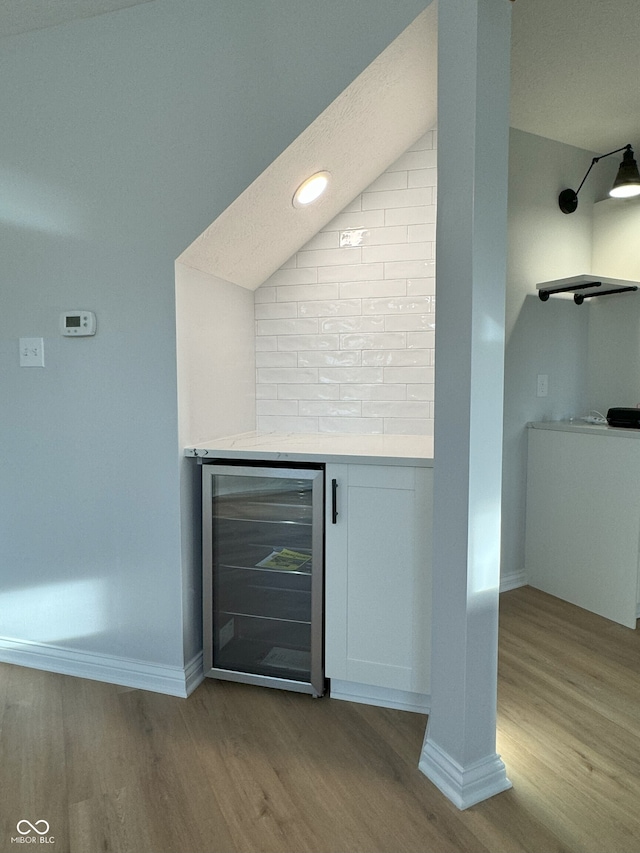 bar featuring white cabinetry, wine cooler, and light wood-type flooring