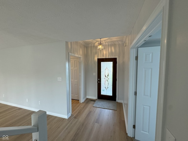 foyer entrance featuring a textured ceiling and light hardwood / wood-style flooring