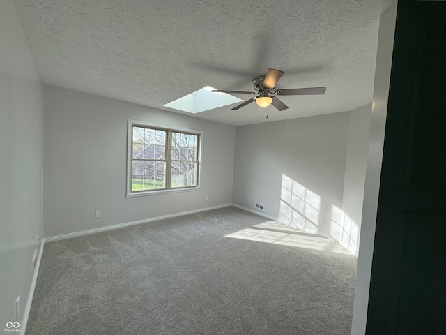 carpeted spare room featuring ceiling fan and a textured ceiling